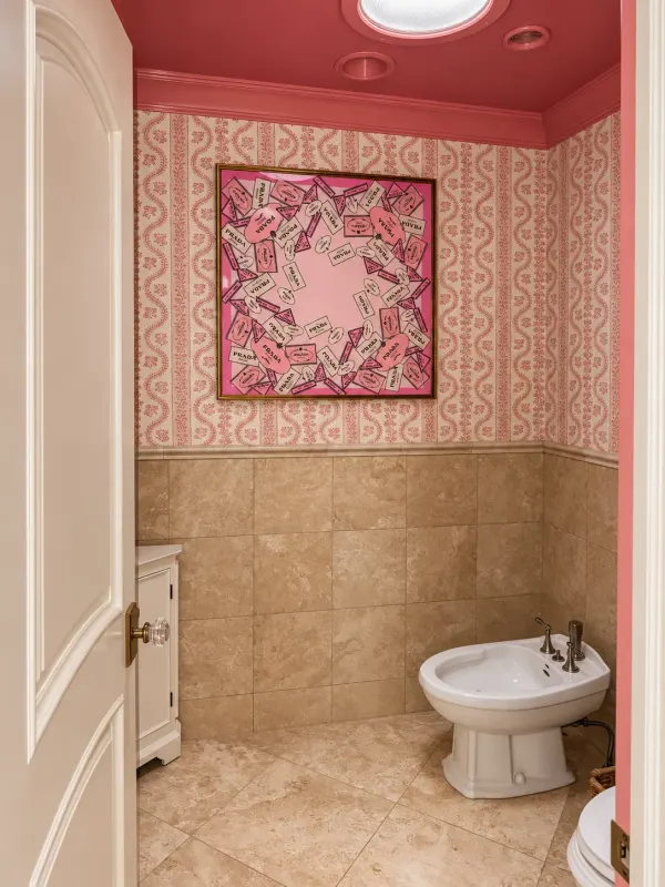 View through the powder-room doorway toward framed pink artwork